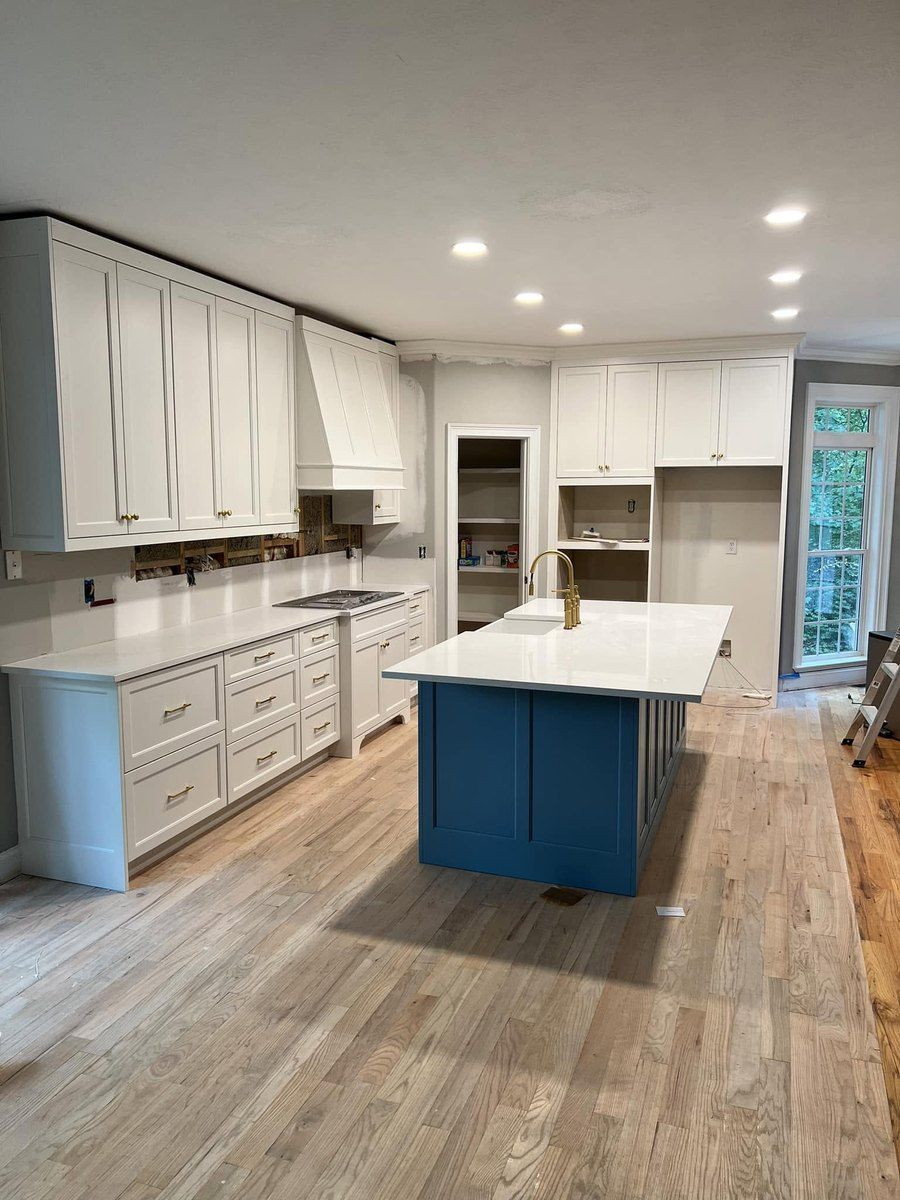 Finished kitchen with white cabinets and a blue island