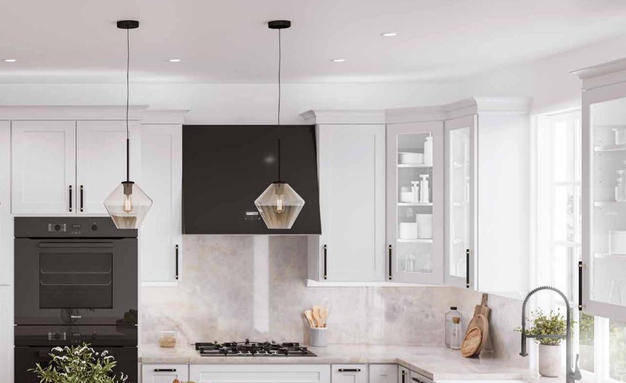 White shaker kitchen with a dark island, pendant lights and a farmhouse sink